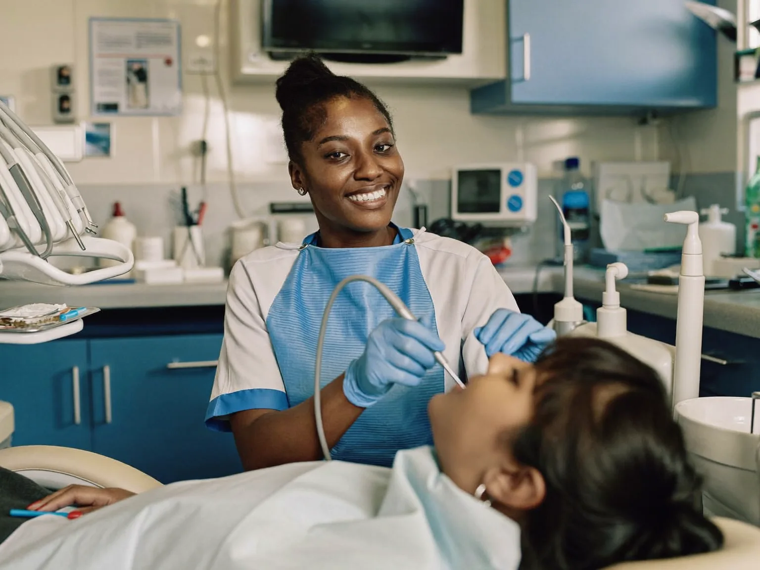 A dentist focused at work in her well-kept clinic (illustrative image)
