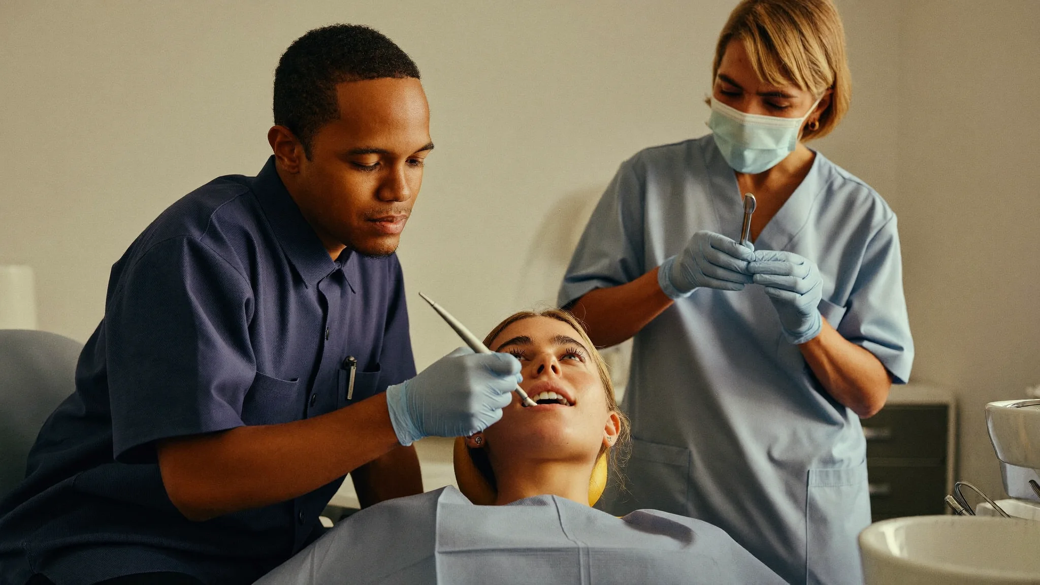 Two dentists collaborating side by side at a dental chair (illustrative image)